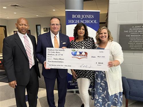 Nancy Reyes holding check with prize patrol 